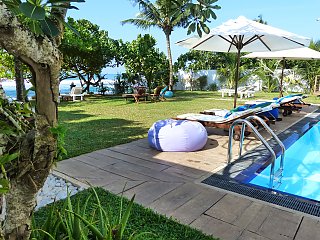 Im Garten des Sithnara Ayurveda Resorts spenden Kokospalmen Schatten