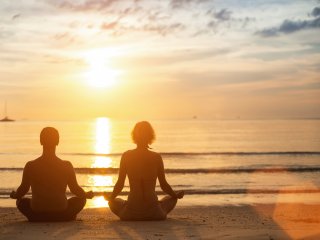 Meditatives Yoga beim Sonnenuntergang am Strand