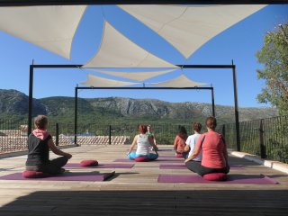 Üben Sie Yoga auf der Plattform mit Blick auf das Karstgebirge