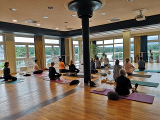 Üben Sie gemeinsam Yoga im hellen Yogaraum