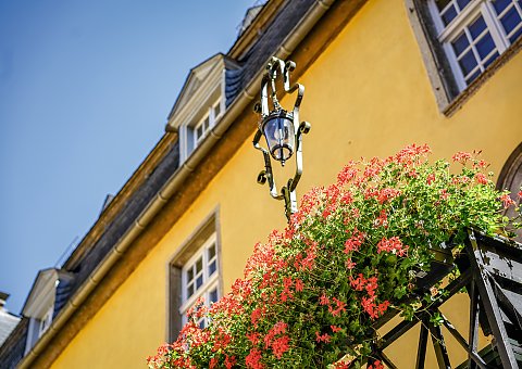 Bunte Blumen säumen die Hauswand des Schlosses Melschede