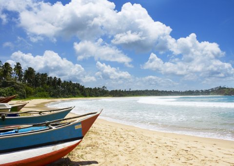 Typische sri lankische Fischerboote zieren den weiten Sandstrand des Talalla Retreats