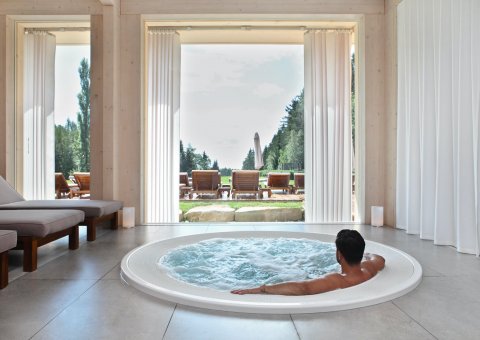 Ein Bad im Whirlpool mit Blick auf den umliegenden Wald