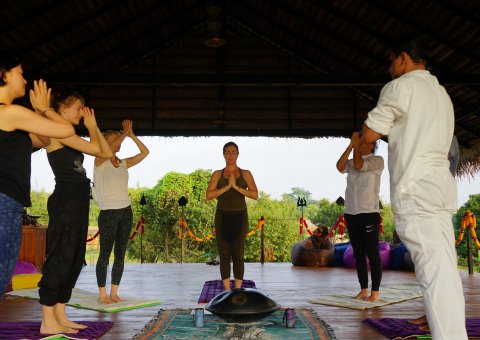 In der luftigen Yogahalle Yoga in der Gruppe praktizieren