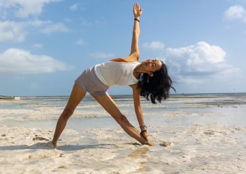 Yoga üben am Strand Sansibars