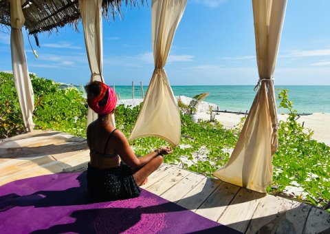 Meditieren Sie mit Blick auf das Meer auf Sansibar