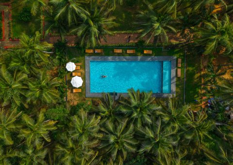 Der Pool inmitten der grünen Anlage des Ayur On The Beach Nattika