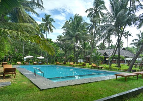 Entspannen Sie sich zwischen den ayurvedischen Anwendungen am Pool unter Palmen